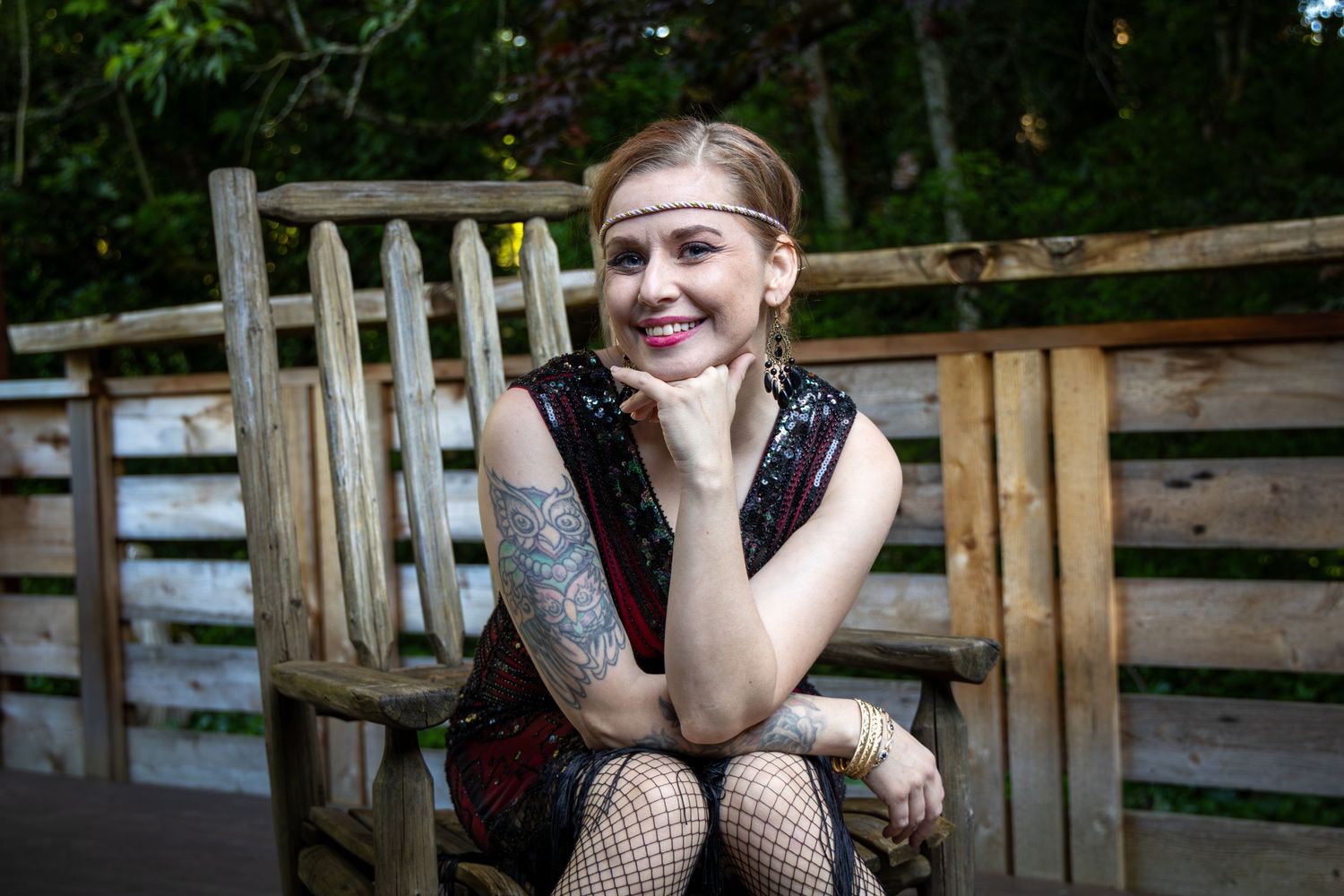 Brianne wearing her 1920 flapper dress leaning forward and a wooden chair