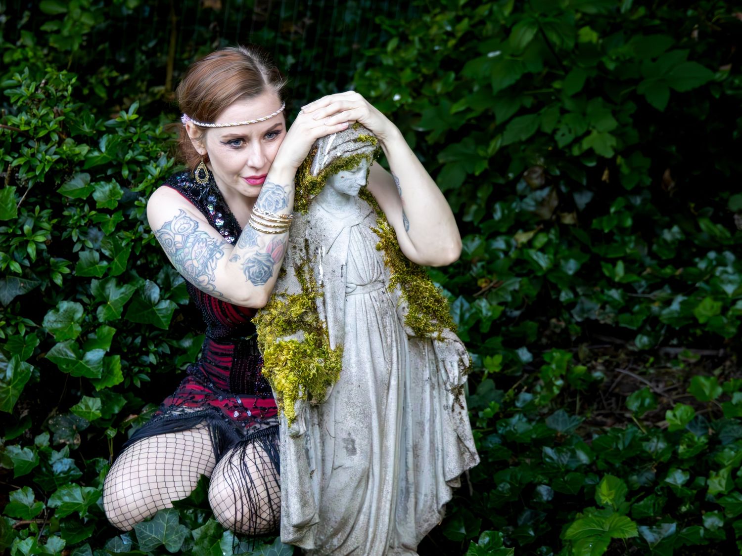 Bree in the garden posing next to a statue