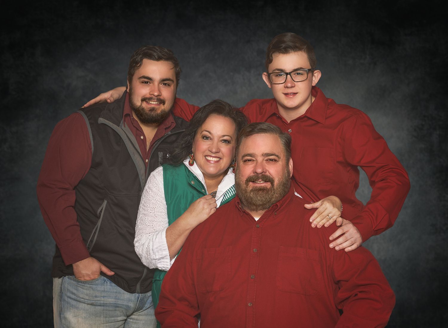 Parents with two teenage boys with red shirts in standard studio pose