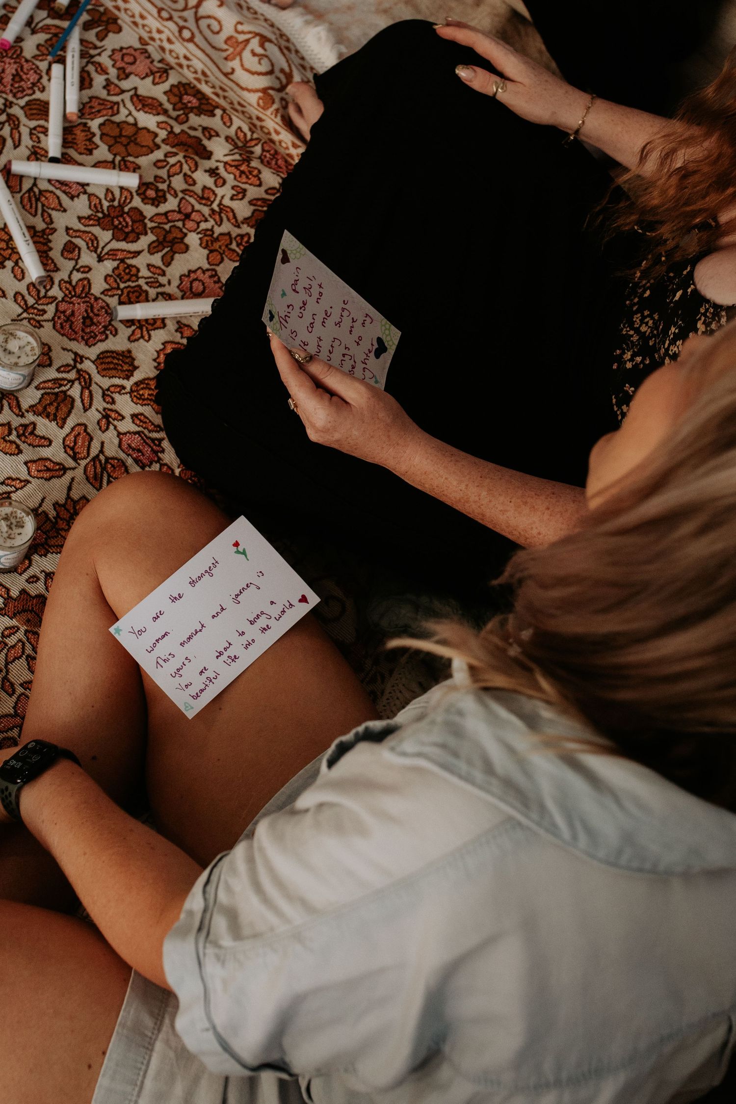 Person sitting on patterned carpet holding handwritten notes in casual indoor setting.