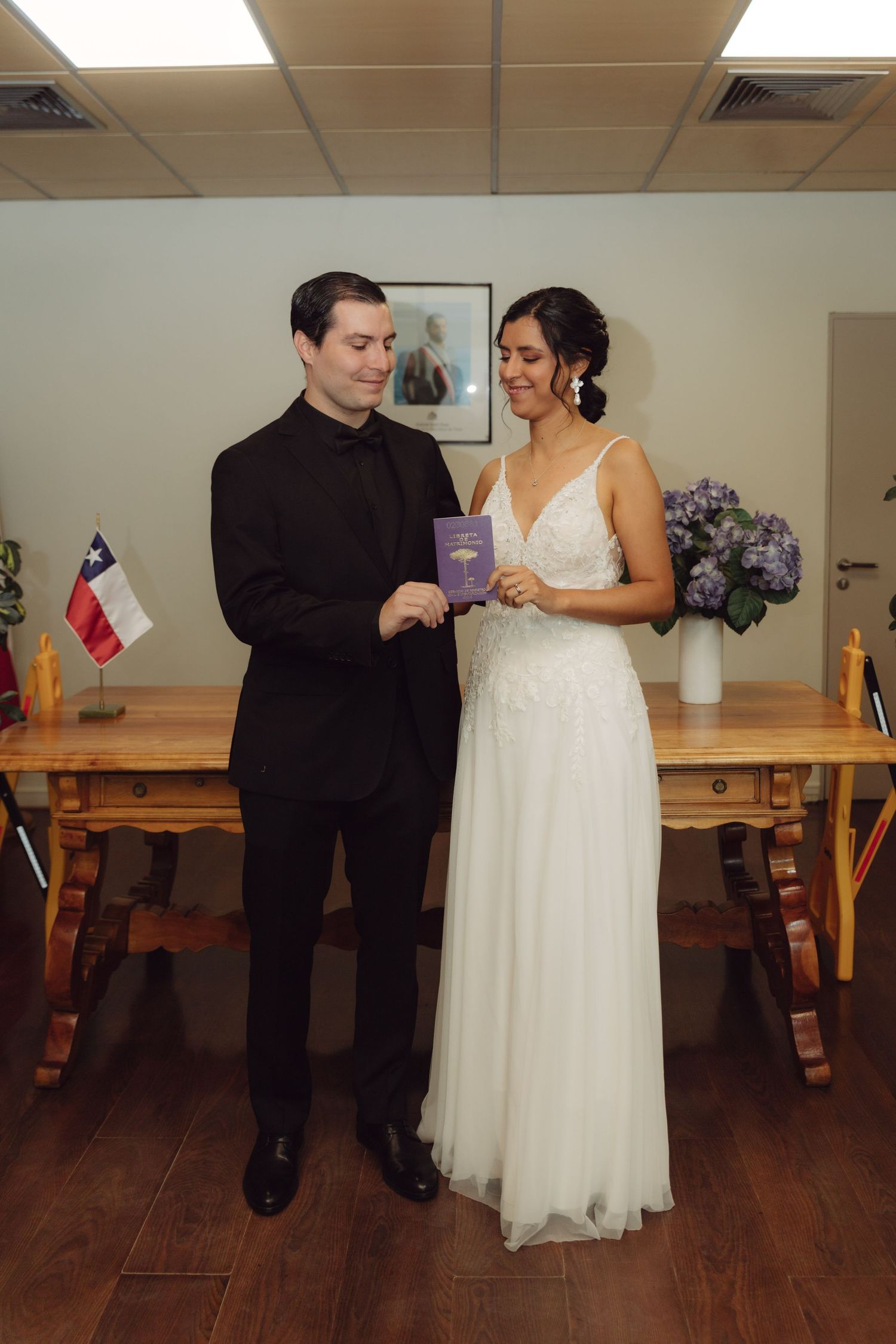 Bride and groom examine marriage certificate together at civil wedding ceremony in Chile.