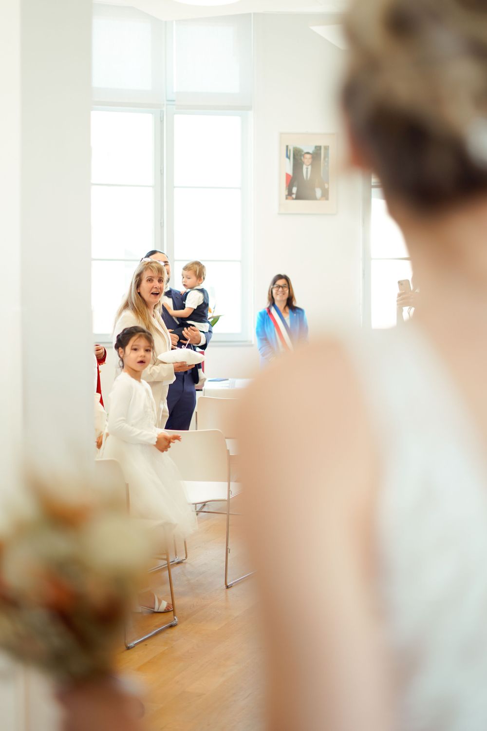 Bright wedding ceremony scene in a white interior room.