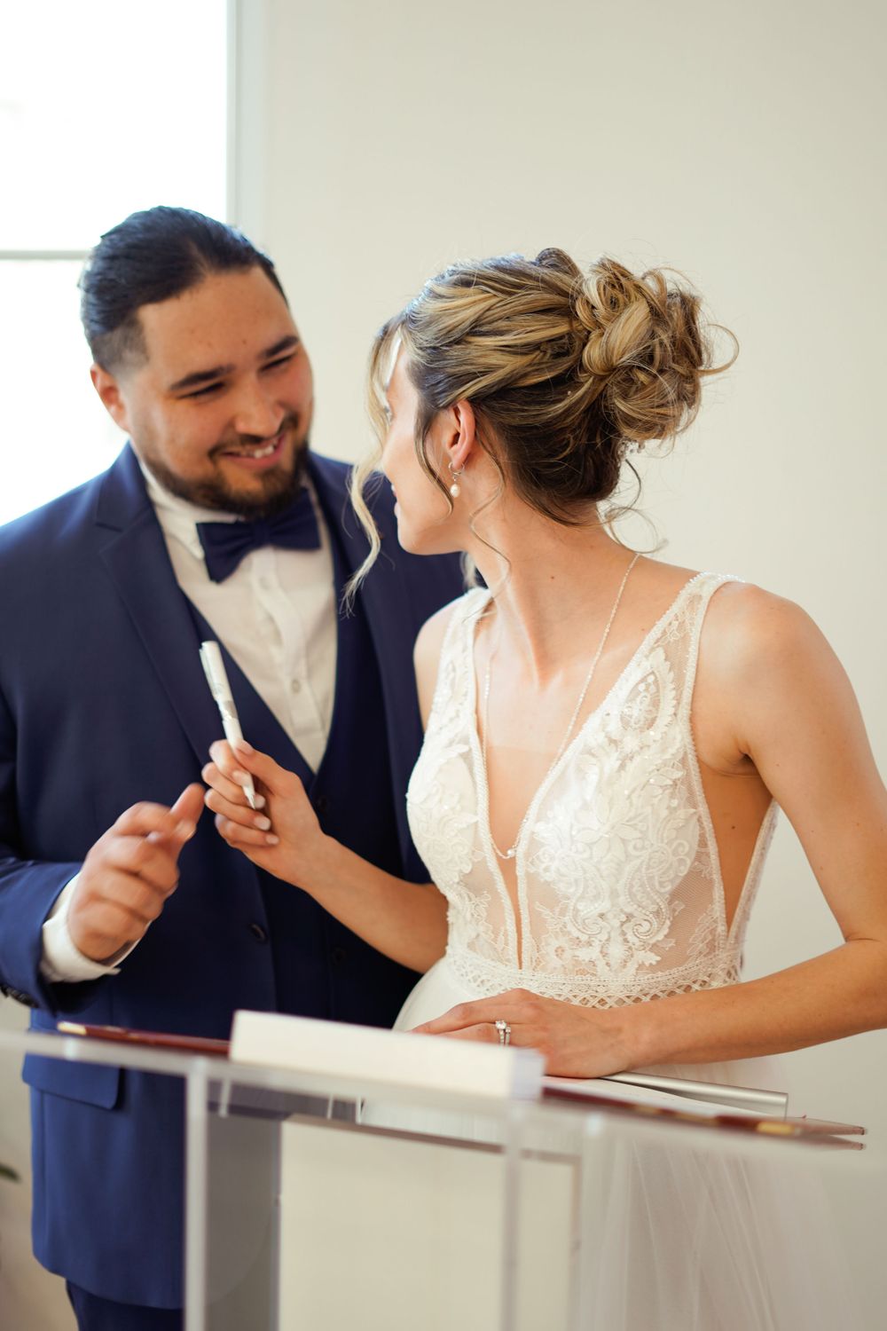 Close-up of wedding ceremony signing moment in formal attire.