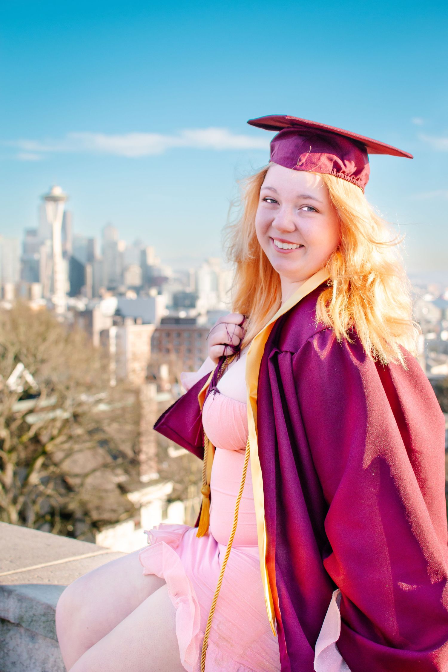 High school senior graduation photo at Kerry Park in Seattle city skyline in the background. Golden hour senior portrait in cap and gown