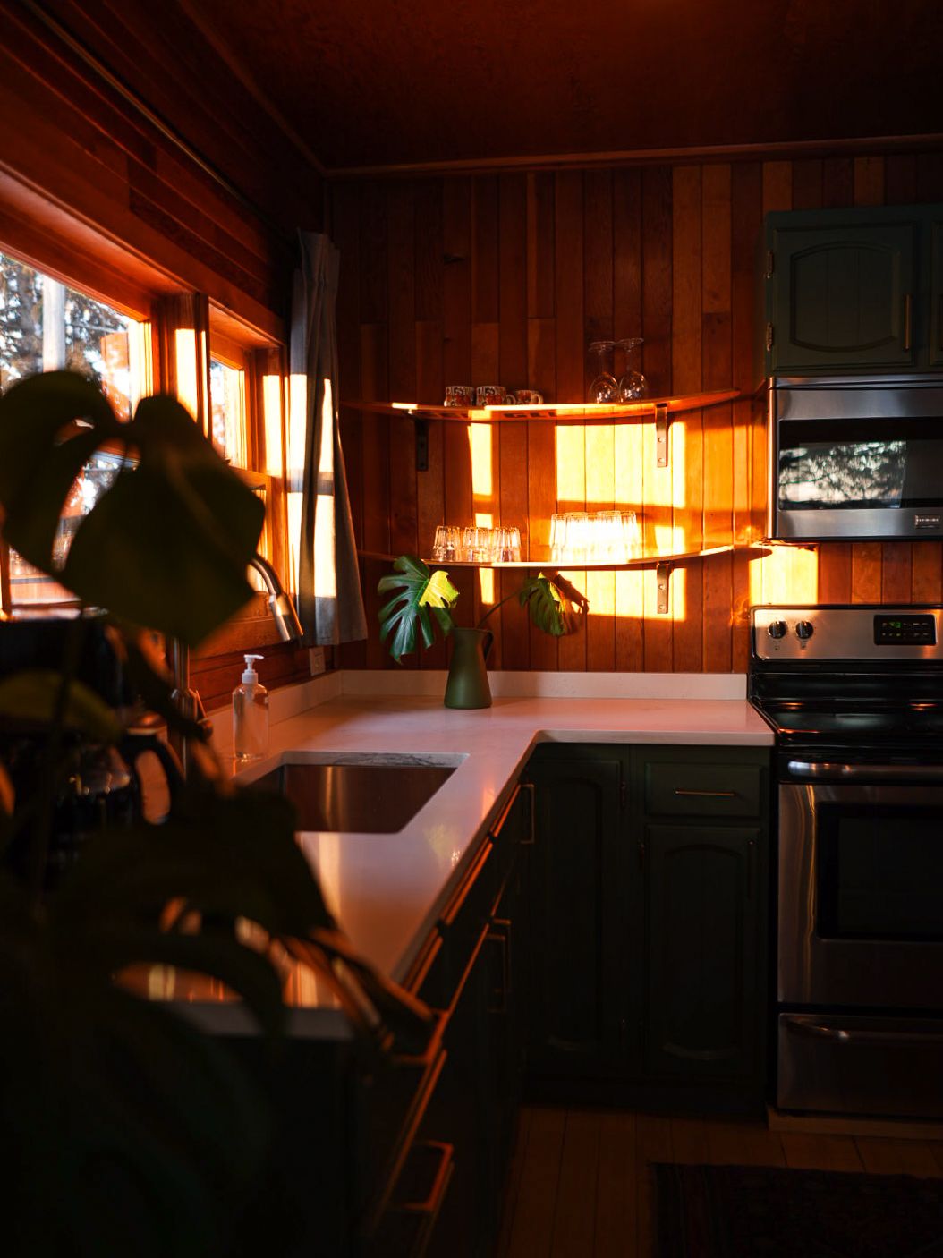 Rustic cabin interior at dusk with warm lighting and wooden walls creating a cozy ambiance.