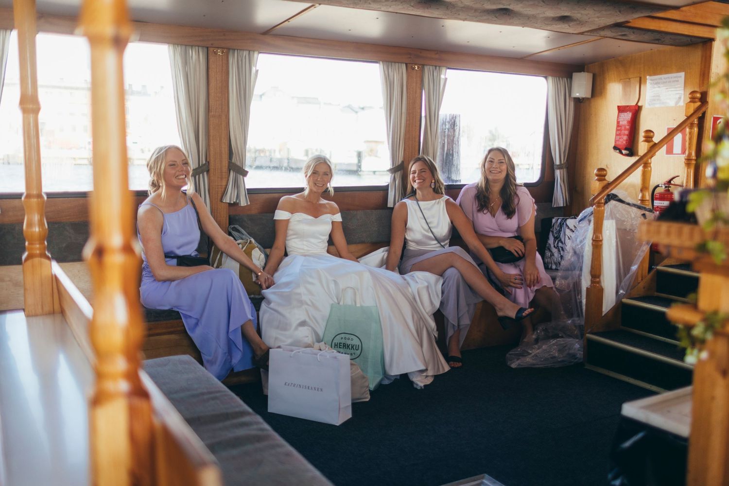 Wedding party relaxes on comfortable seating in an elegant indoor venue space.