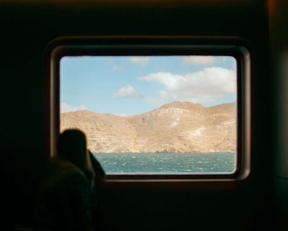 Framed view from ship window with woman watching the sea