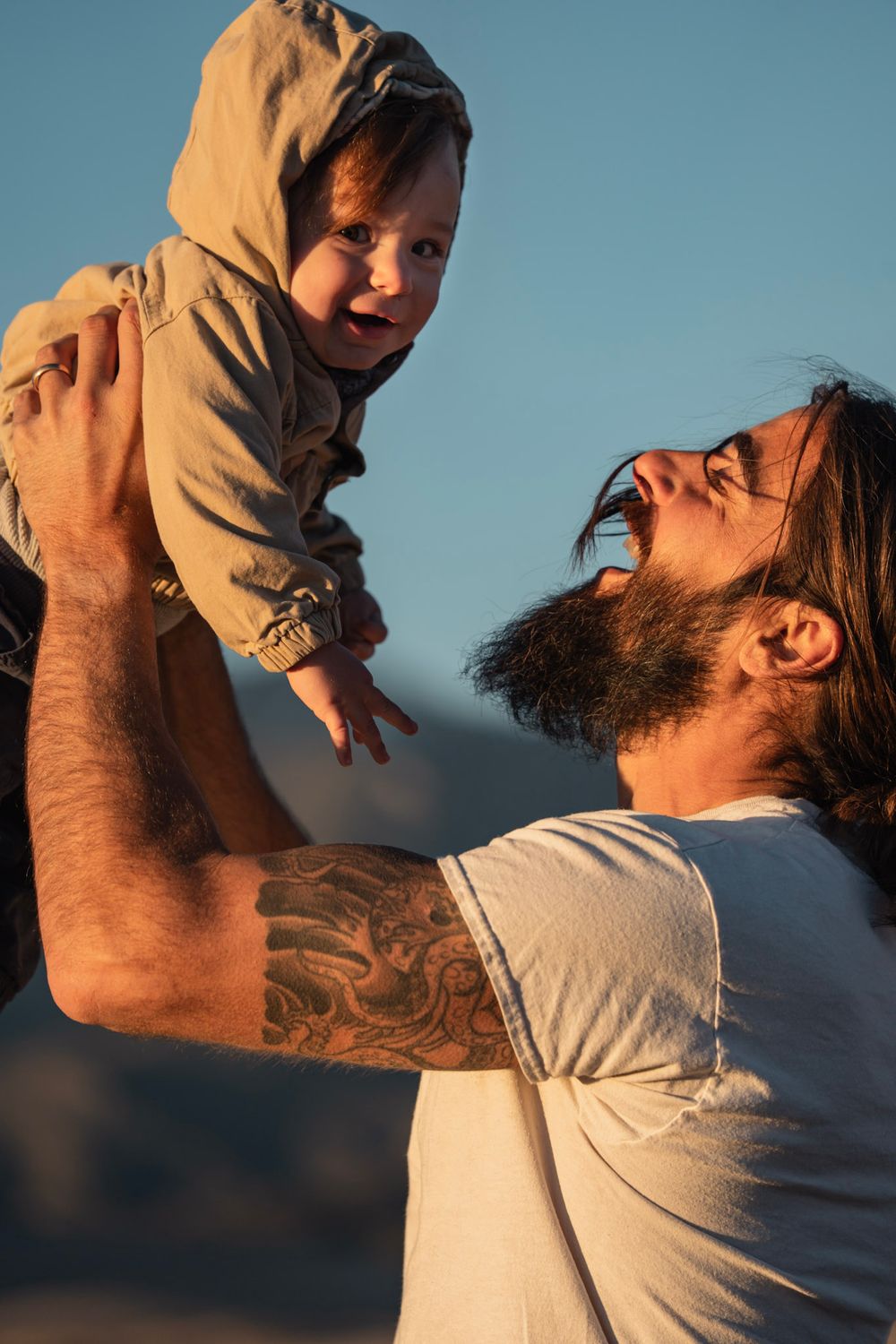A playful moment captured between parent and child in warm sunset lighting. Family photos great sand dunes national park