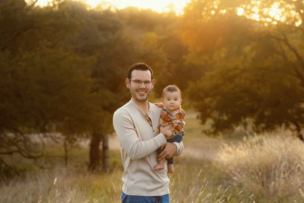 Sweet family portrait in golden sunset field.