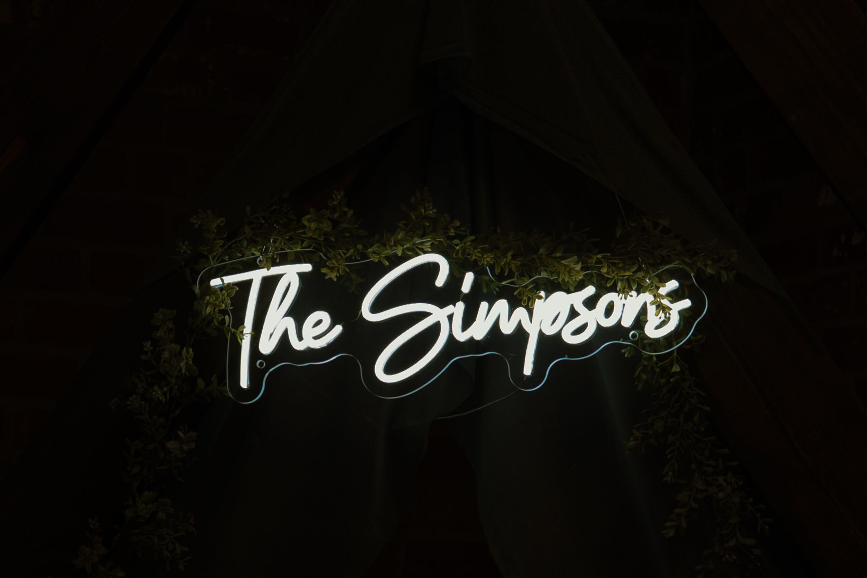 Illuminated neon wedding sign glowing in the dark.
