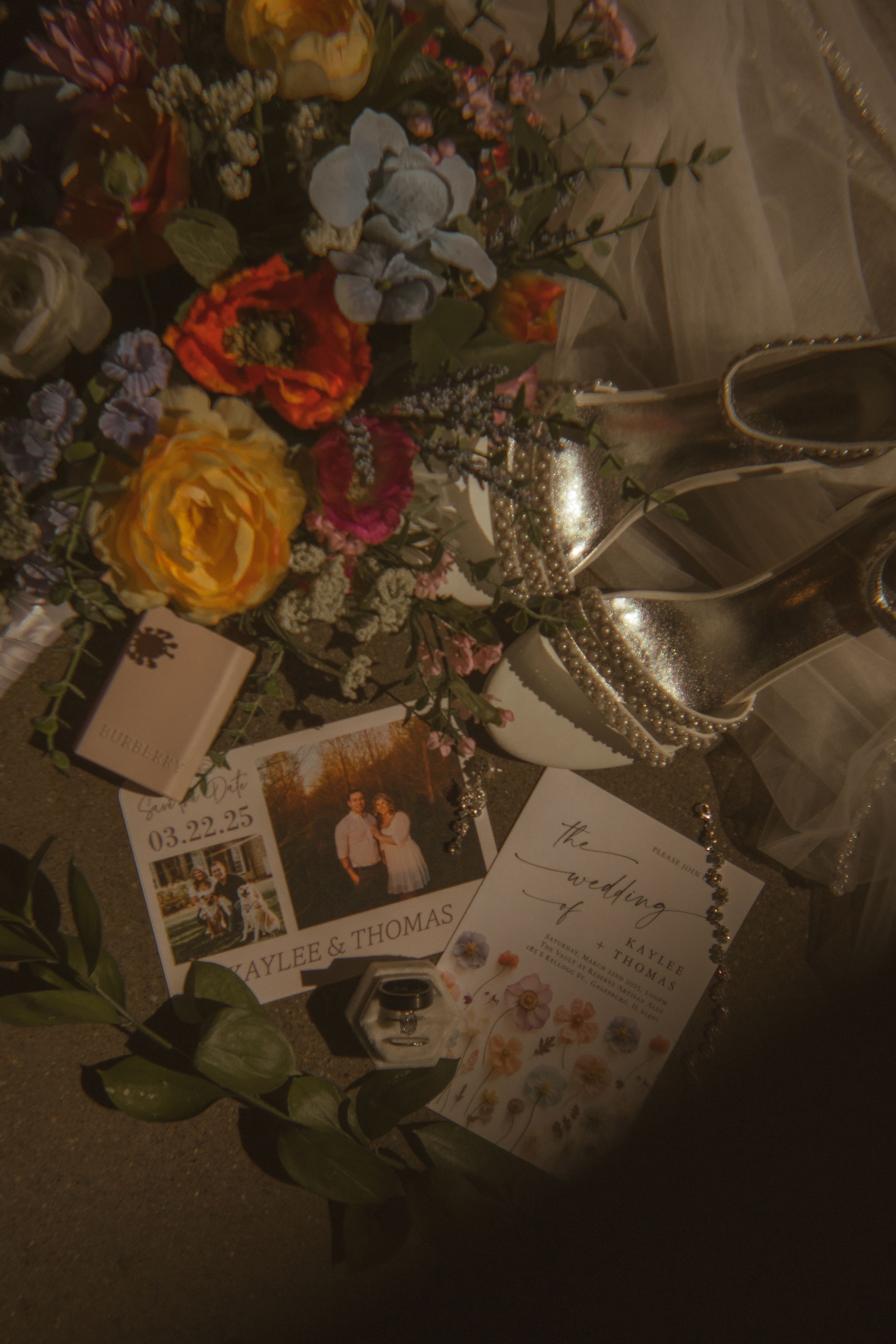 Wedding reception details with floral arrangements and cards in dim lighting.