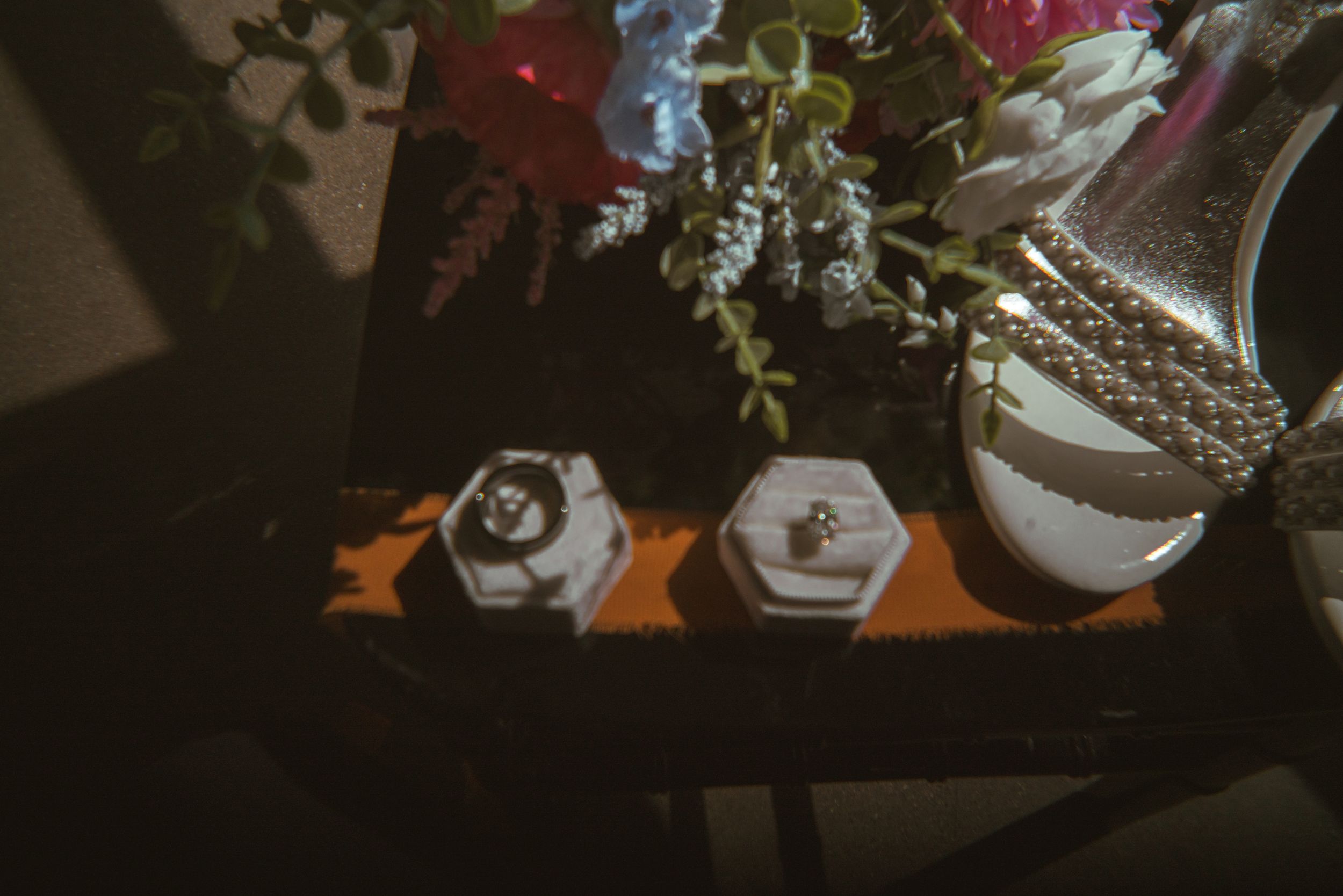 Artistically arranged wedding decorations and flowers in moody lighting.