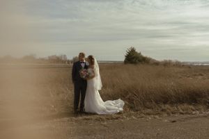Wide panoramic view of a wedding ceremony in a rustic outdoor setting.
