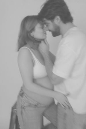Pregnant woman and her partner about to kiss