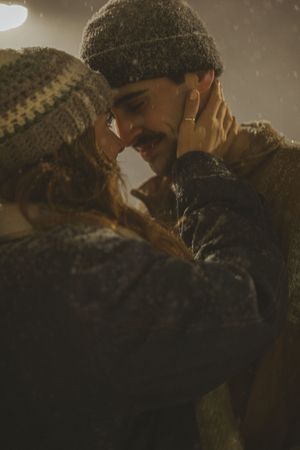 A couple in medieval or historical dress share an intimate moment in sepia-toned lighting.