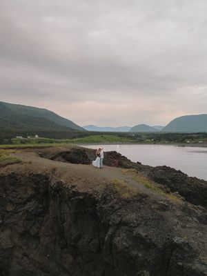 Panoramic series of a rocky coastal landscape at dusk with mountains and water in the distance.