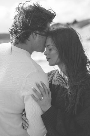 A romantic black and white photo series showing a couple in an intimate embrace on a bright, hazy day.