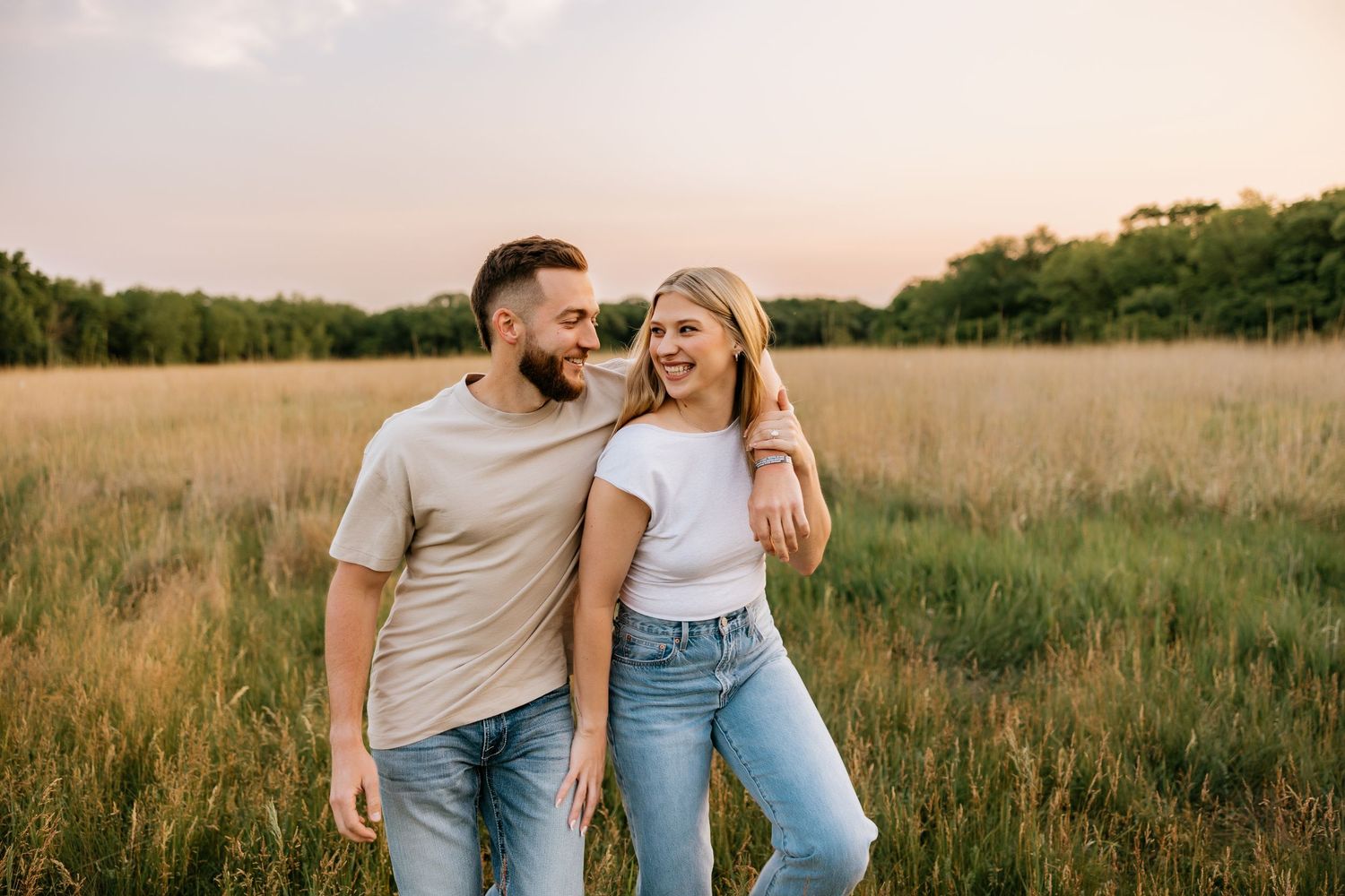 Engaged couple laughing and twirling in the sunset at Riverside Golf Course in Riverside, Illinois.