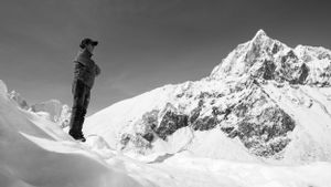 Black and white photograph of steep snow-covered mountain peaks in dramatic lighting.