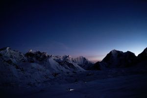 Mountainous horizon with snow-covered peaks stretching across a twilight panorama.