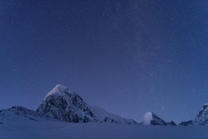 Snow-capped mountain ridges extending into the distance under a clear blue sky.