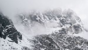 Misty mountain peaks shrouded in clouds create a dramatic winter panorama.