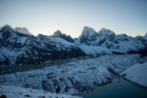 Snow-covered mountain range stretches across the horizon under a clear blue sky.
