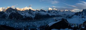 Panoramic view of jagged mountain peaks stretching across the horizon under blue skies.