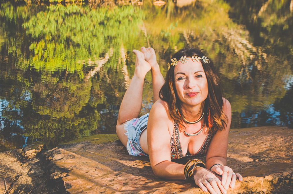 Bohemian styled portrait with floral crown by reflective water.