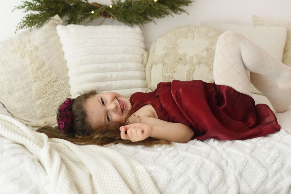 A person in a red sweater lies peacefully asleep on white bedding in a series of connected images.