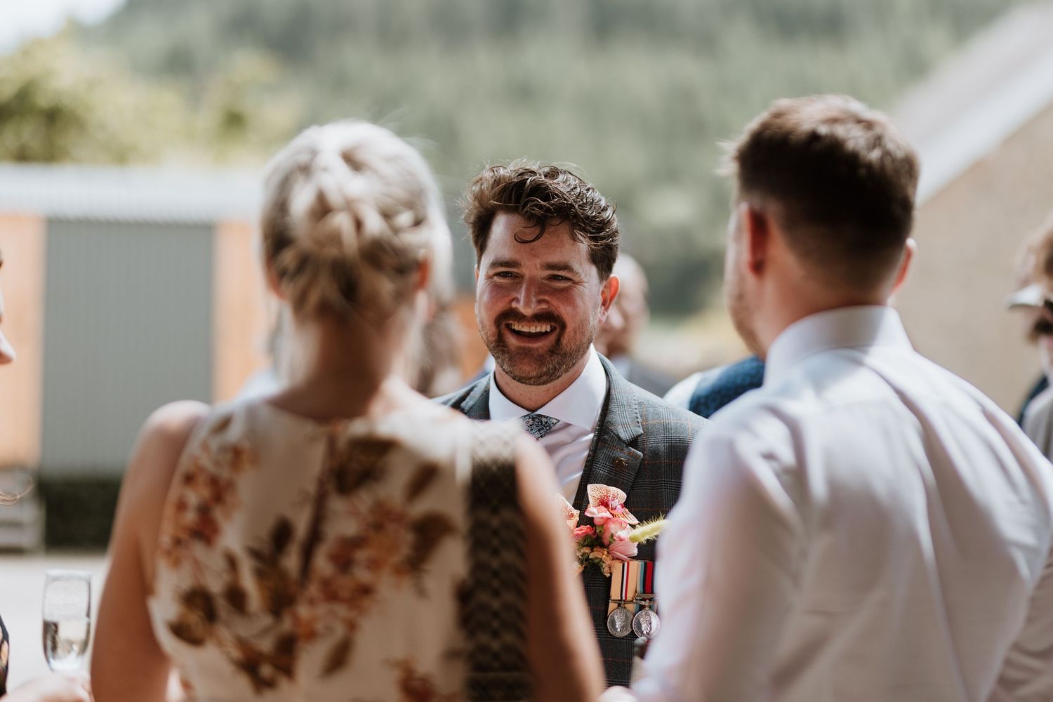 A joyful moment captured during an outdoor wedding ceremony with guests sharing laughter in natural lighting.
