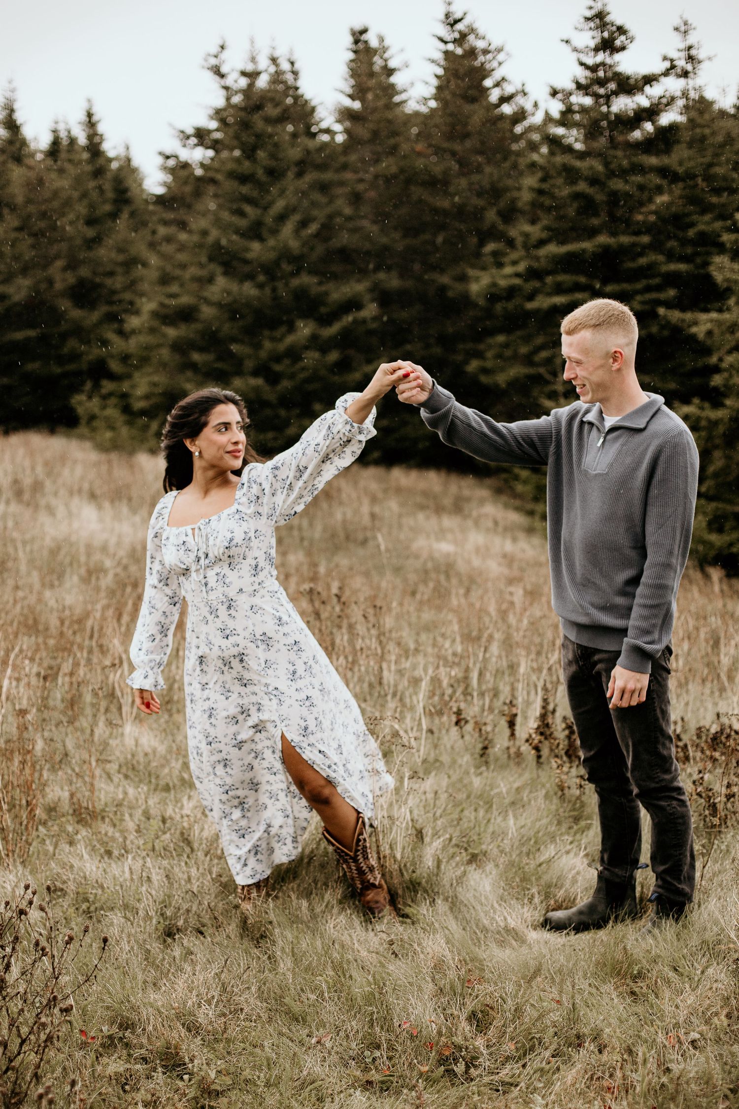 man twirling woman while dancing in a field