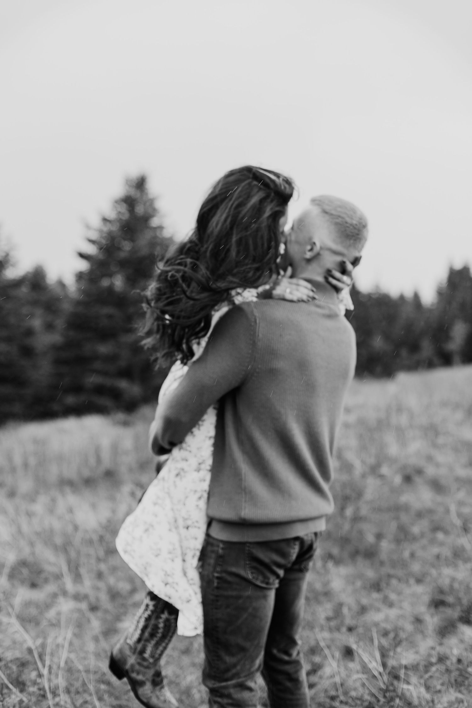 man lifting woman up in his arms and swinging her around while kissing
