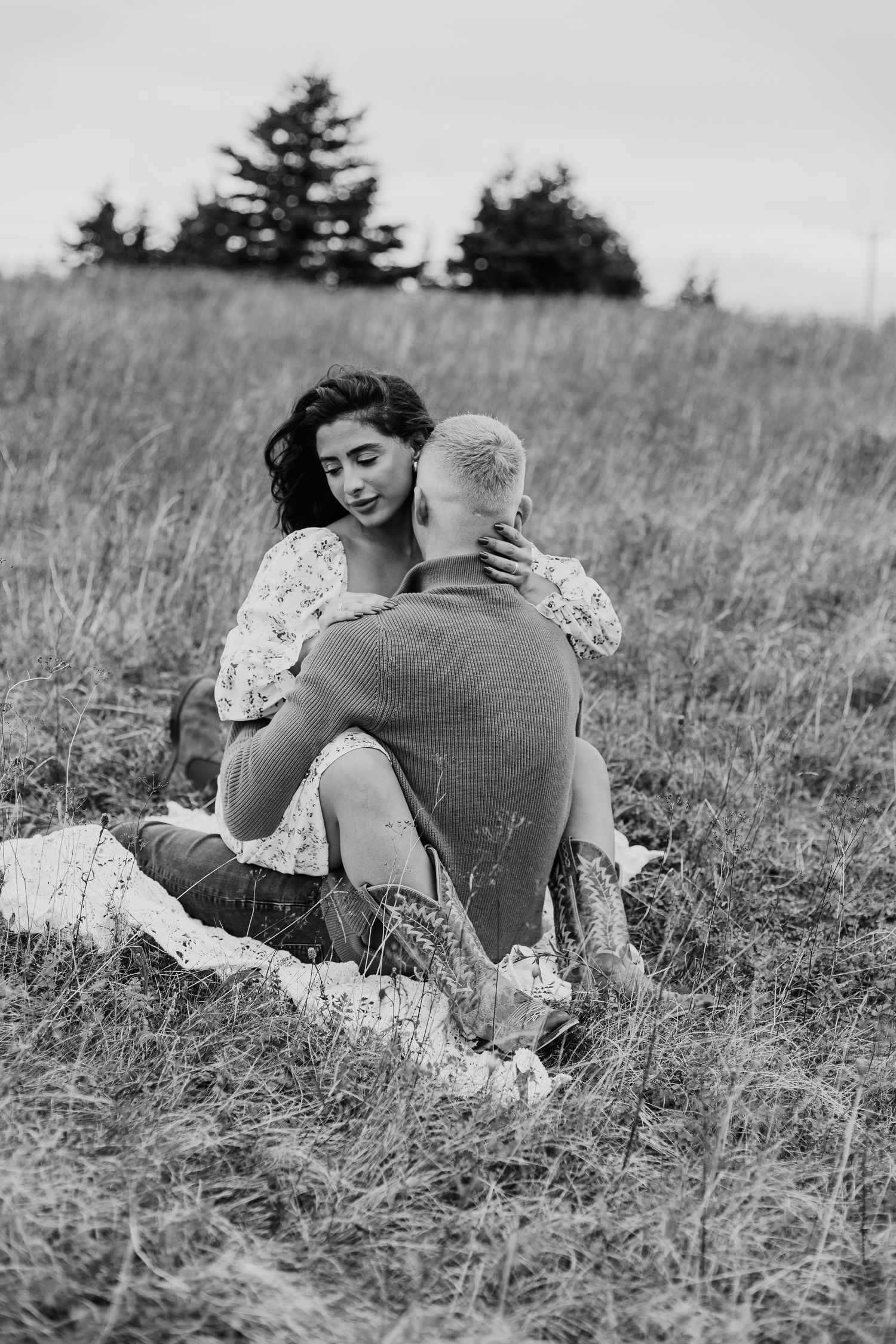 woman sitting in man's lap facing each other, man kissing woman's neck