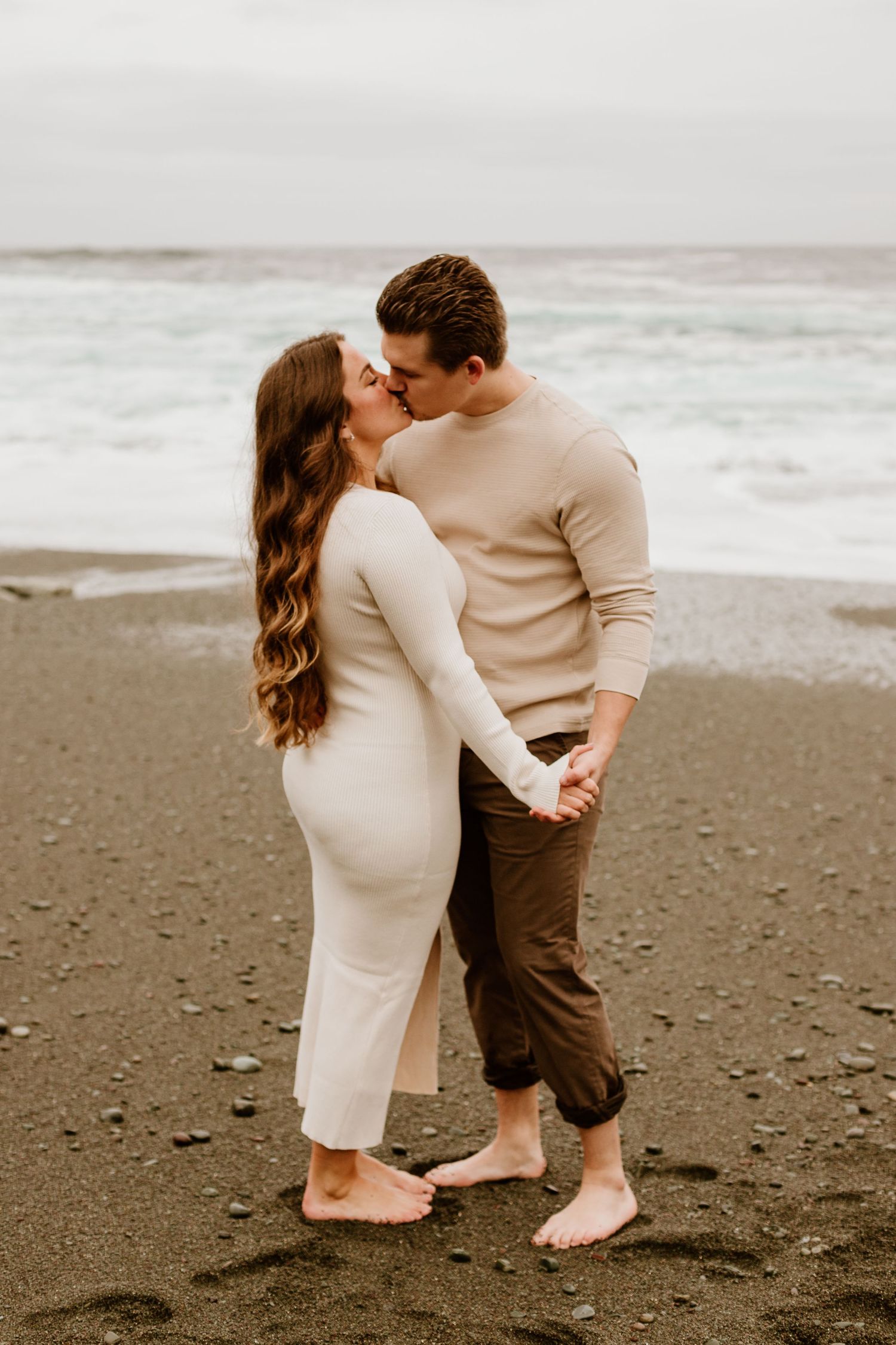 newly engaged couple kissing while dancing on the beach in Newfoundland
