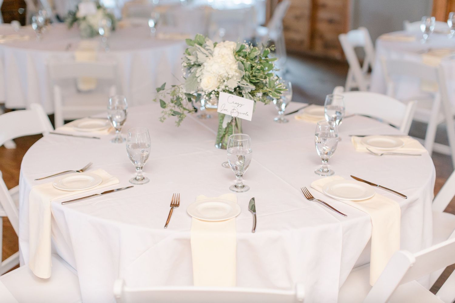 Rustic dining table settings with wine glasses and candles arranged in a refined indoor table setup for a special occasion.
