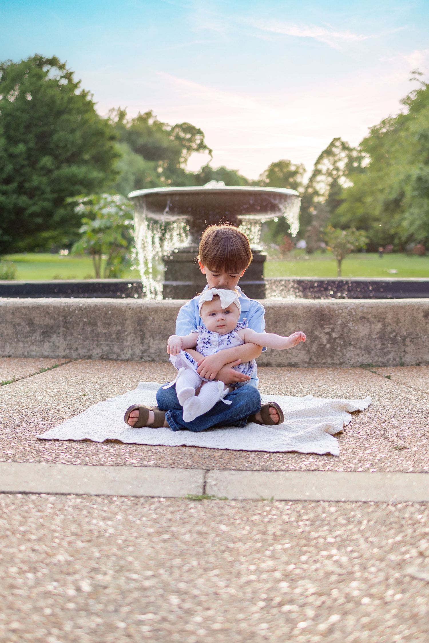 Springfield, IL family photographer captures two siblings in front of a foundation at Washington Park Botanical Gardens in Central IL