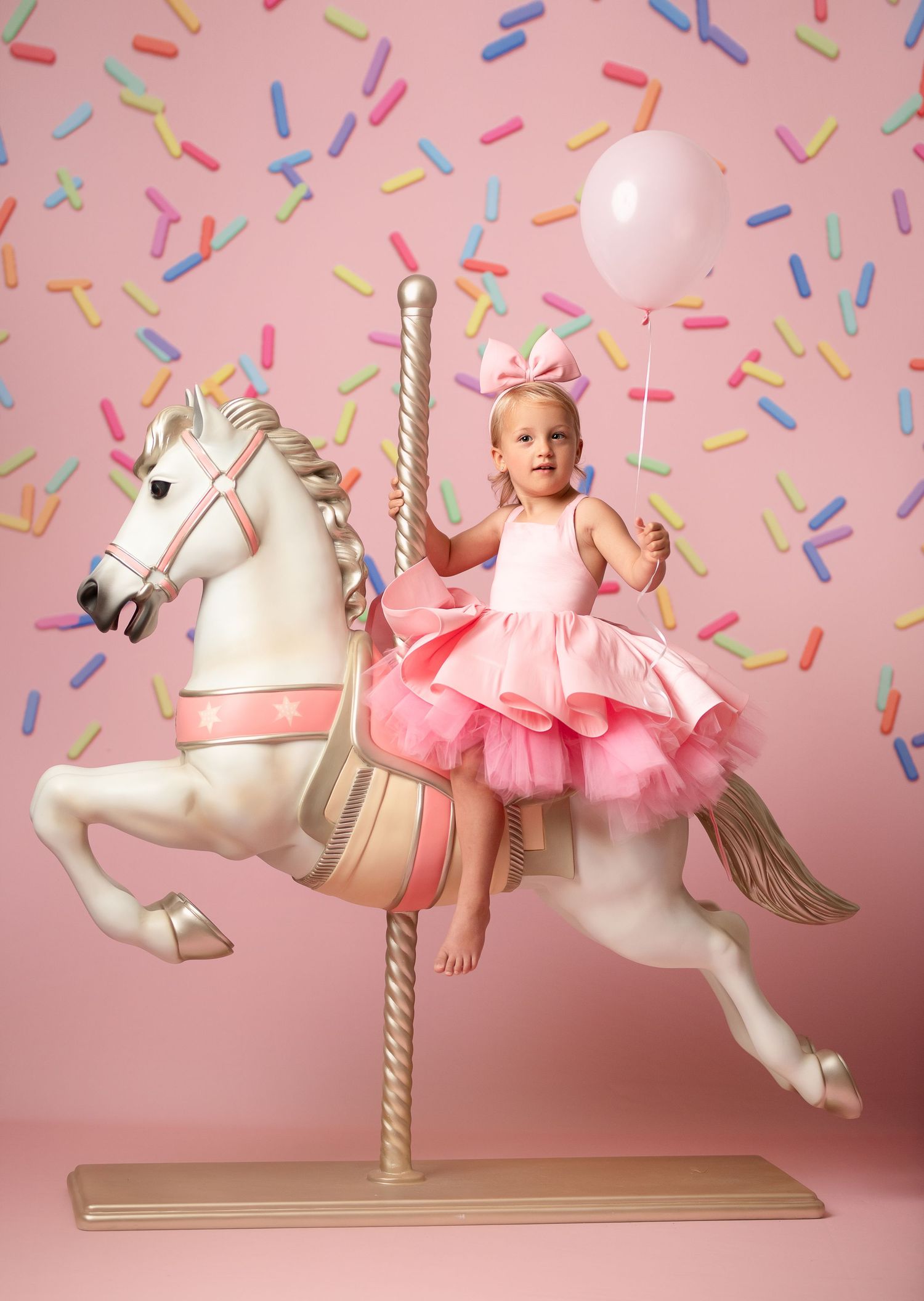 Carousel horse evolution from left to right shows pink tulle decor and colorful confetti against a pink background.