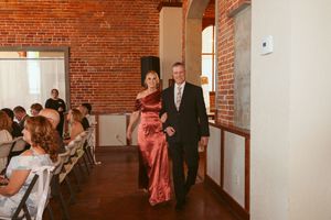 Elegant reception hall with exposed brick walls and wooden floors set up for a rustic indoor celebration.