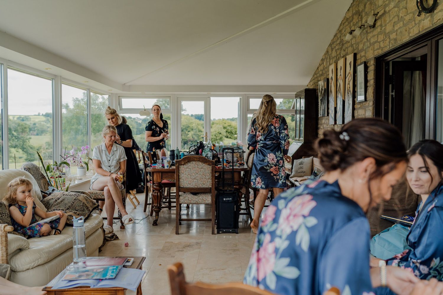 Wide angle view of a bright interior space with people gathered for preparations.