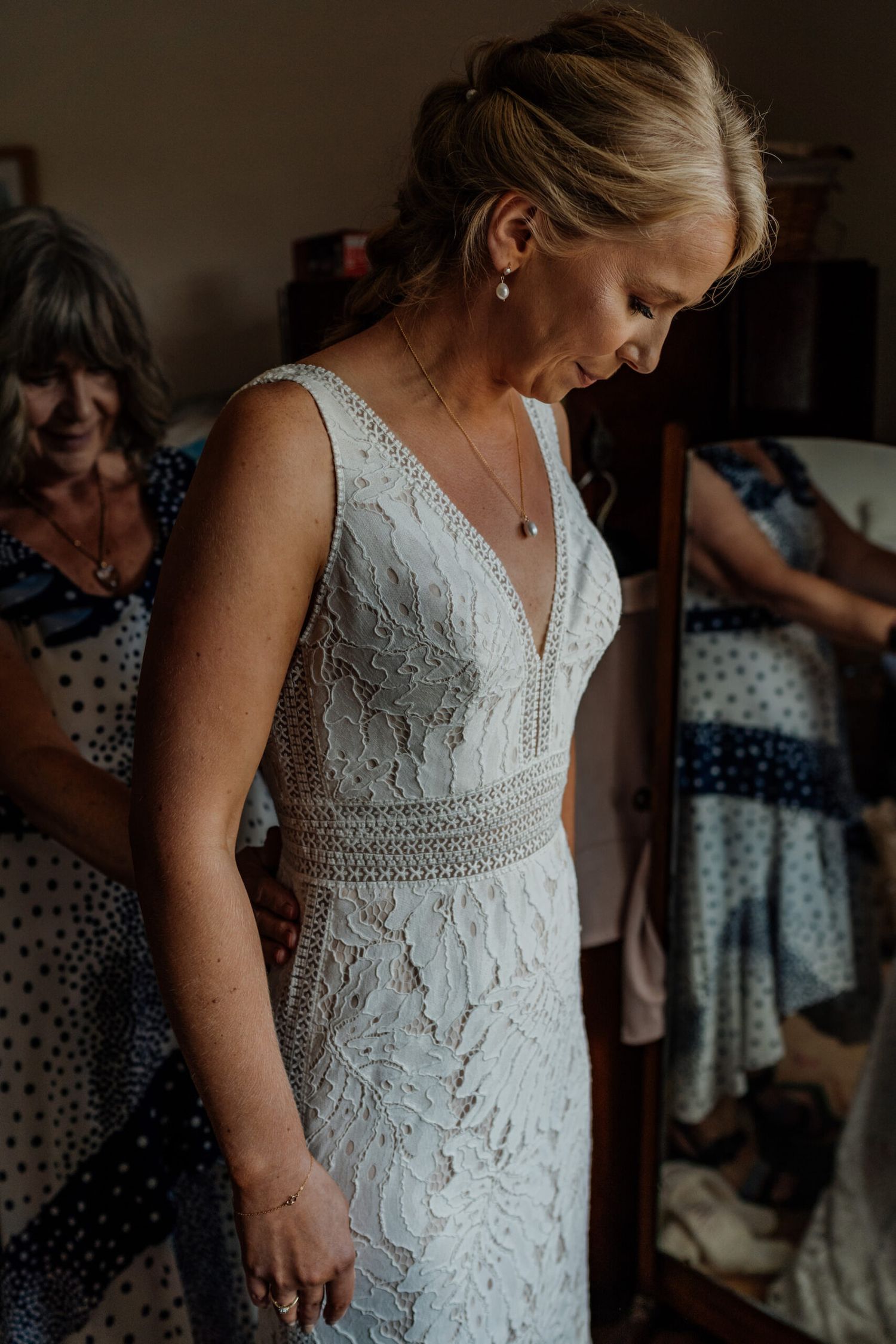Intricate white lace wedding dress with v-neck design captured in intimate detail.
