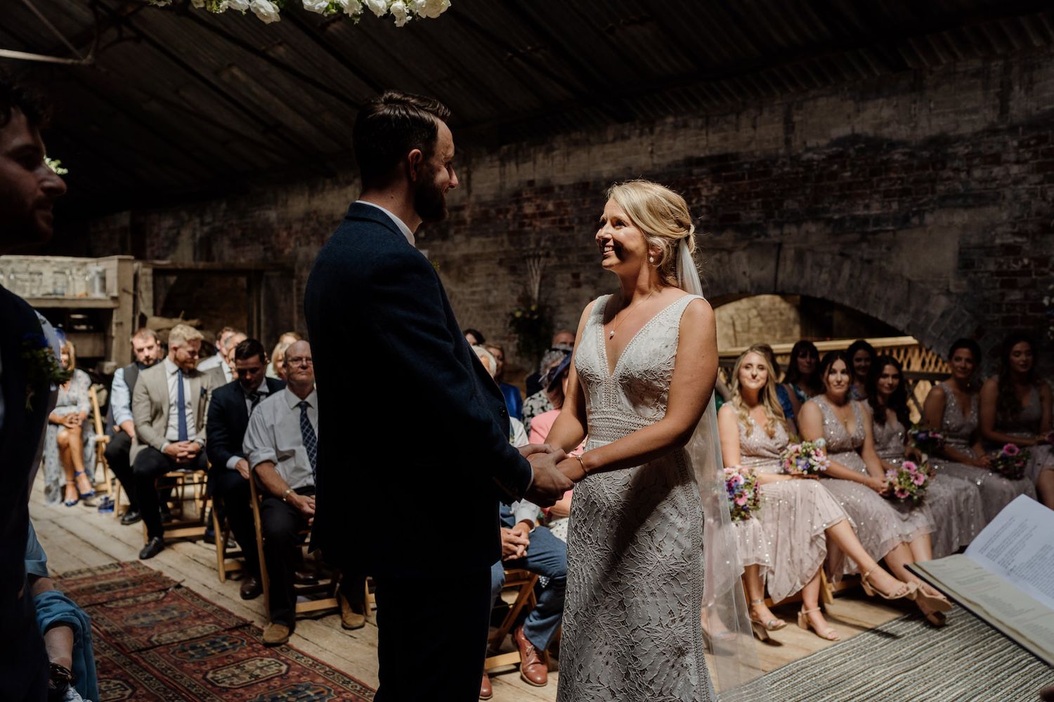 An intimate wedding ceremony taking place in a rustic industrial venue.