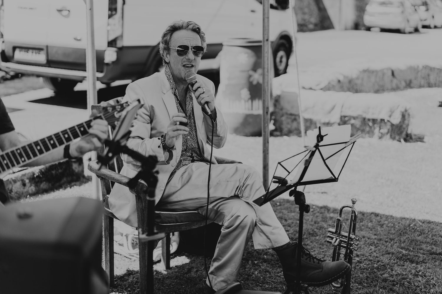 Musicians play instruments outdoors at a daytime event.