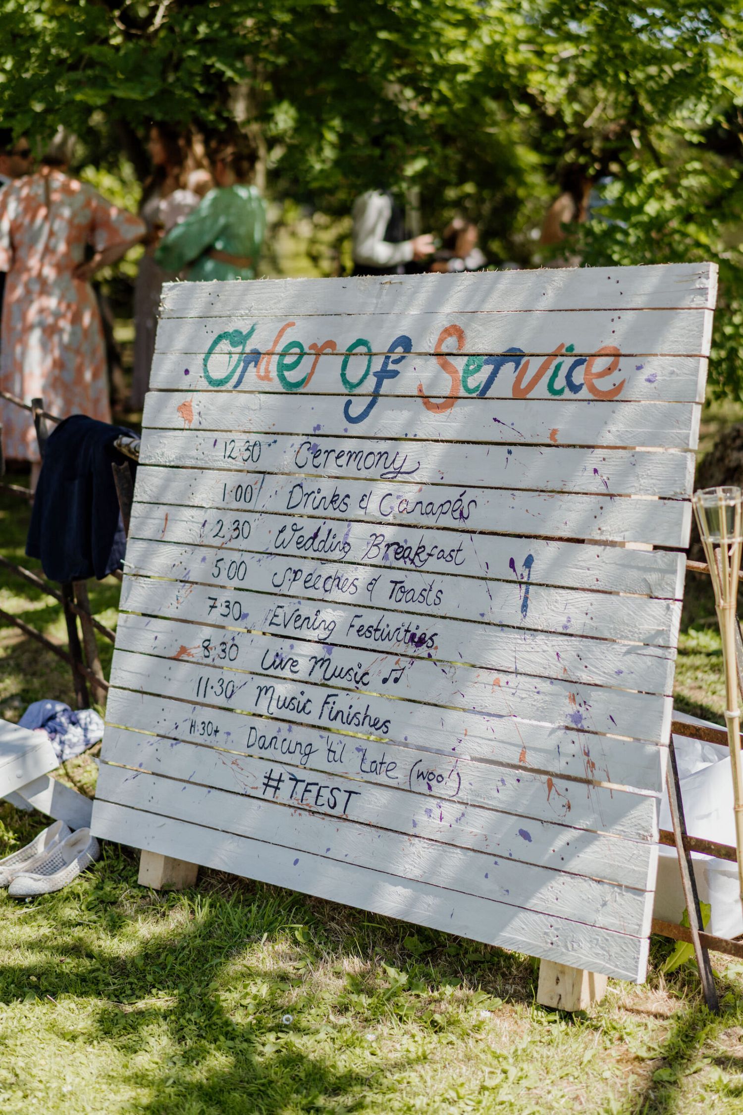 Rustic wooden order of service board displaying wedding day timeline and schedule.