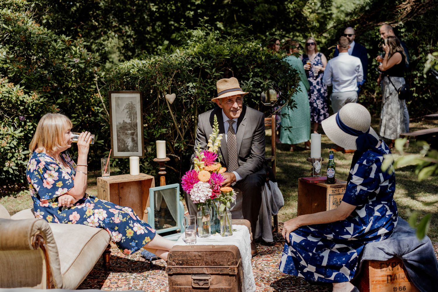 Guests enjoying refreshments at an outdoor event with vintage decorations and flowers.