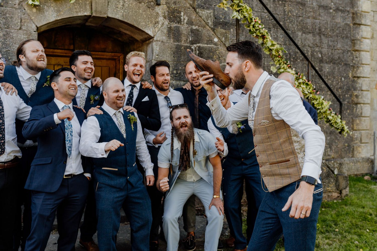 Wedding celebration group photo with bridal party in navy and grey attire.