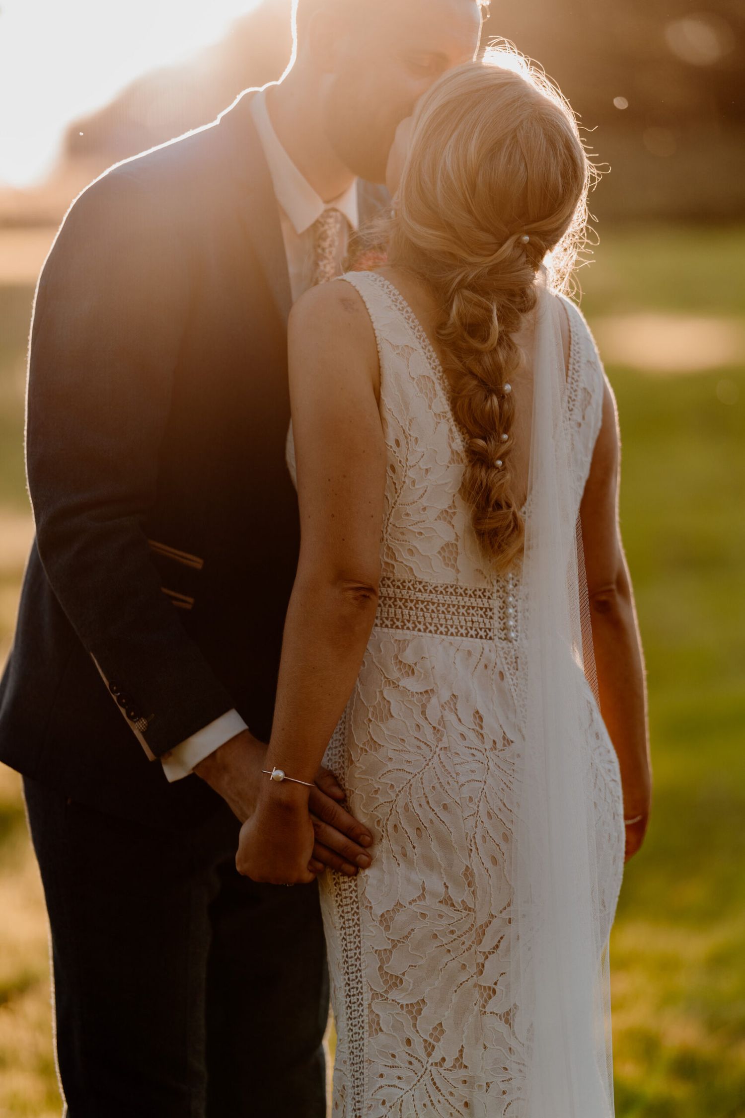 Golden hour wedding portrait showing intricate details of lace dress.