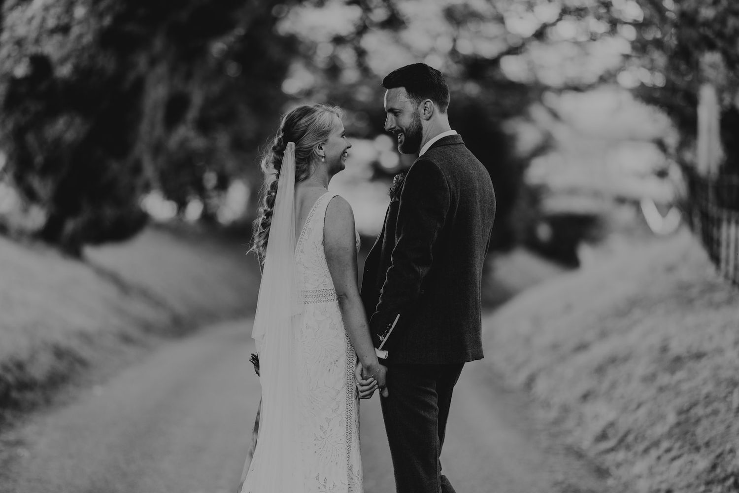 Black and white wedding portrait on hillside path.