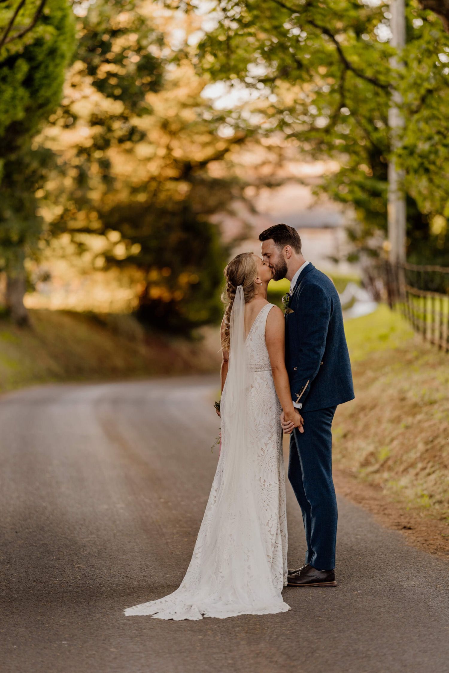 Romantic autumn wedding photos on tree-lined country road.