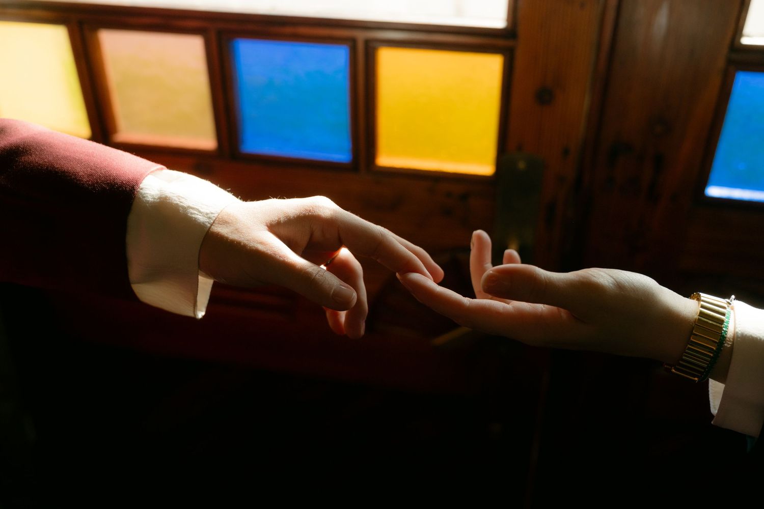 close up m/f arms - f holding his arm and they have tattoos and a wedding ring